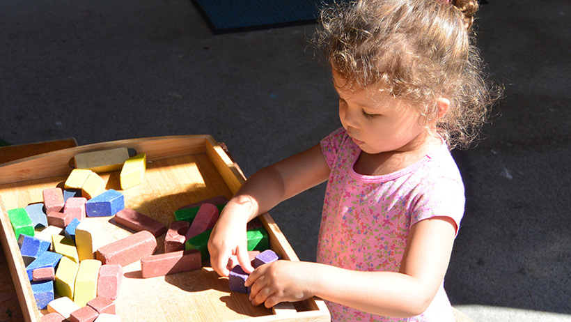 girl playing with blocks at daycare