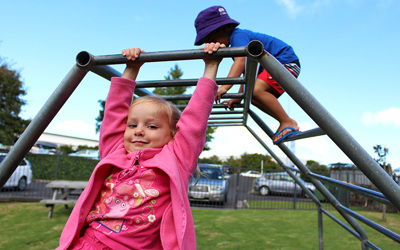 girl swinging on bars at childcare