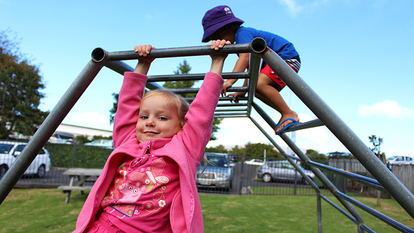 girl swinging on bars at childcare